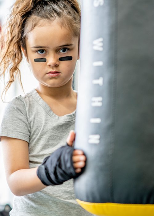 7 year old girl taking boxing lessons in a training facility as a form of exercise and self defence.
